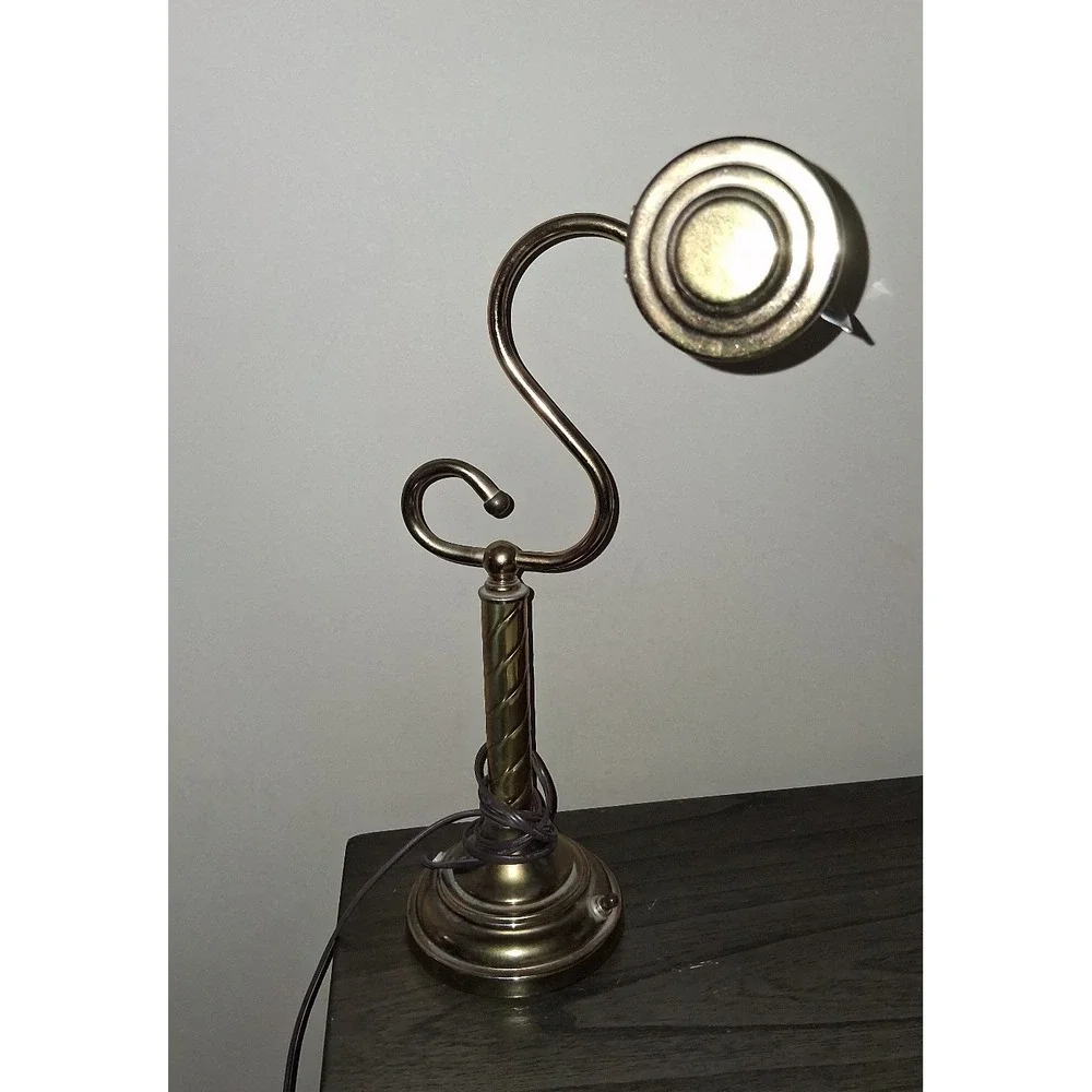 Vintage brass tone desk lamp with elegant scroll arm and classic piano light